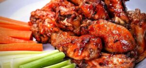 Fighting Cock Root Beer Chicken Wings glazed with sweet and smoky root beer BBQ sauce, served hot and ready for National Chicken Wing Day.