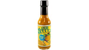 Tropical pineapple hot sauce bottle with bright island flavors, spicy peppers, and sweet citrus heat inspired by Key West tropical cooking.